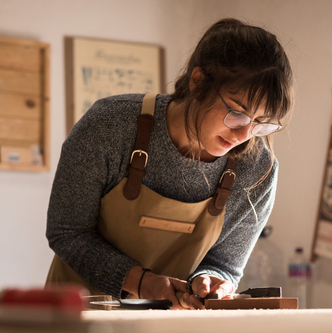 White woman in apron etching in her workshop