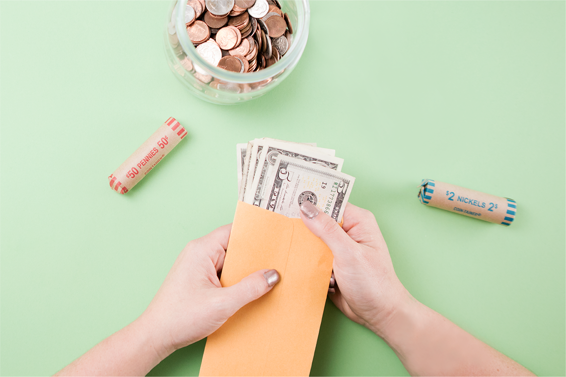 Jar of coins and envelope of dollar bills